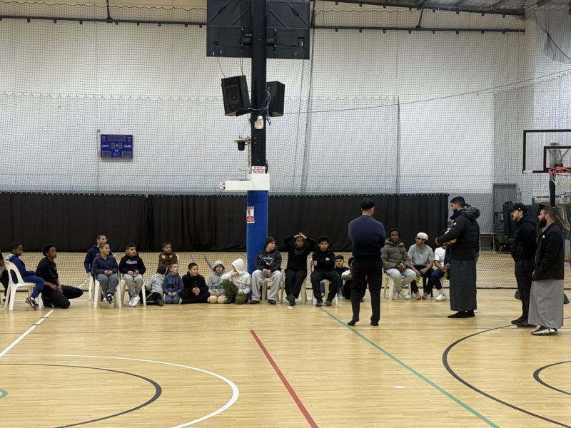 Boys sitting along the side of the court between games