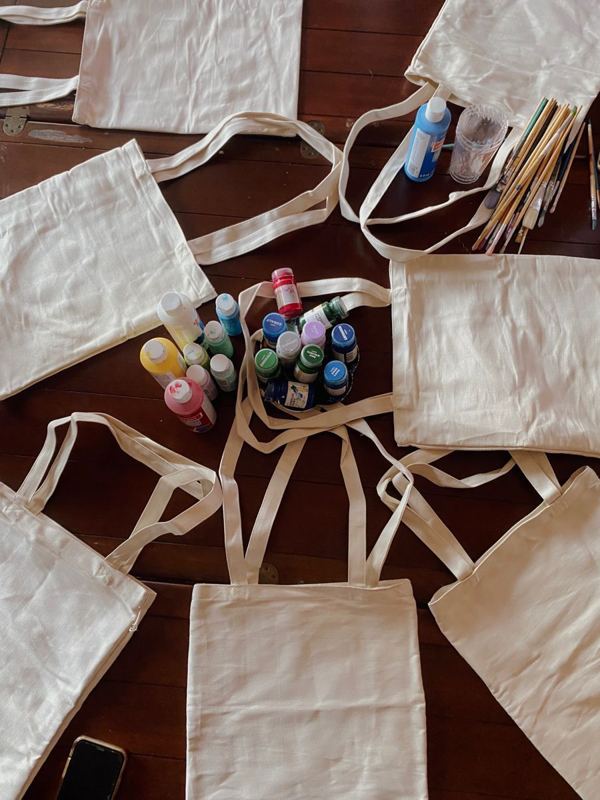 Tote bags and fabric paints laid out for tote bag night